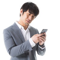 どのプレイリストを再生しようか悩む会社員男性の写真