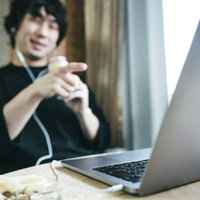 ストロングゼロを片手にリモート飲み会する男性の写真