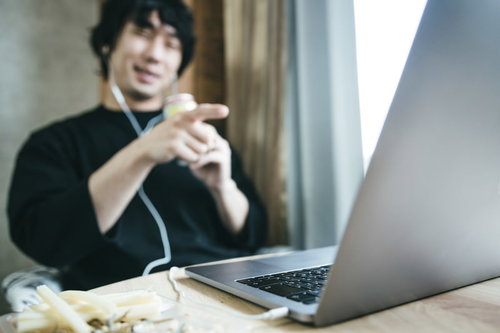 ストロングゼロを片手にリモート飲み会する男性
