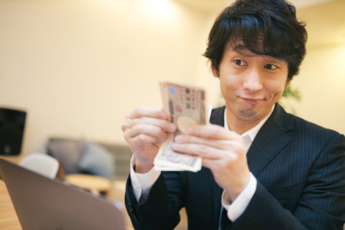 10万円ゲットだぜ！現金を手にしてにやける男性