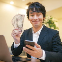 10万円は推しに課金するスーツ姿の男性のお金と満足の写真