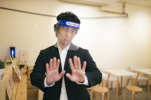 「密です！」フェイスシールドで接触拒否するビジネスマン