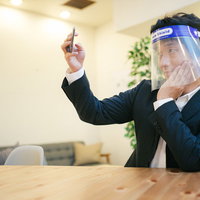フェイスシールドを着用して自撮りする男性の写真