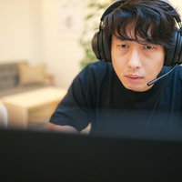 ヘッドセットを装着してプレイに集中するゲーマー男性の写真