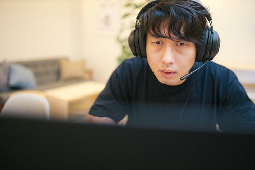 ヘッドセットを装着してプレイに集中するゲーマー男性