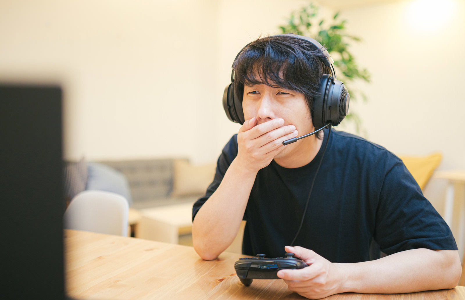 ヘッドセットを装着してゲームに負けてショックを受ける男性［モデル：大川竜弥］