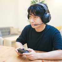ヘッドセットを装着してスマートフォンでゲームをするゲーマーの写真