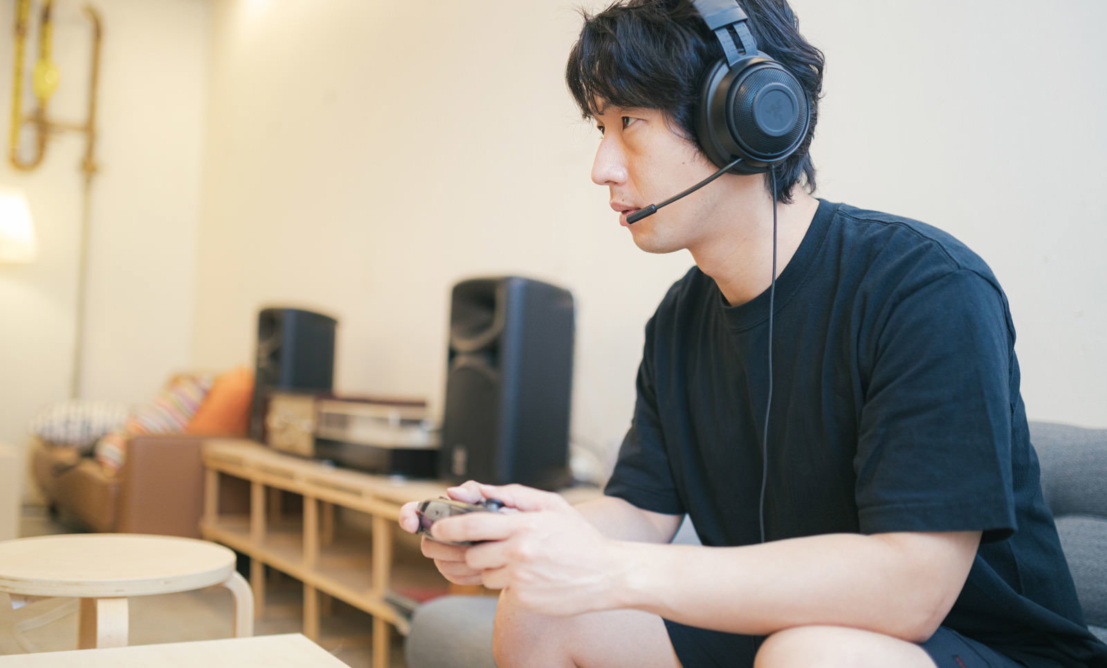 ヘッドセットを装着してゲームに集中している男性［モデル：大川竜弥］