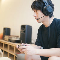 ヘッドセットをしながらゲームに熱中する男性ゲーマーの写真