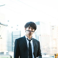 ボールペンを手にシンキングタイムに入るジャーナリスト男性の写真