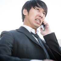 飲み会当日、予約が取れていなかったことに焦る幹事男性の写真