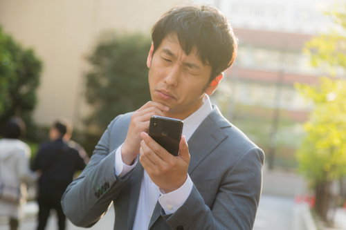 気になるあの娘は今晩も既読スルー、スマートフォンを見つめる男性