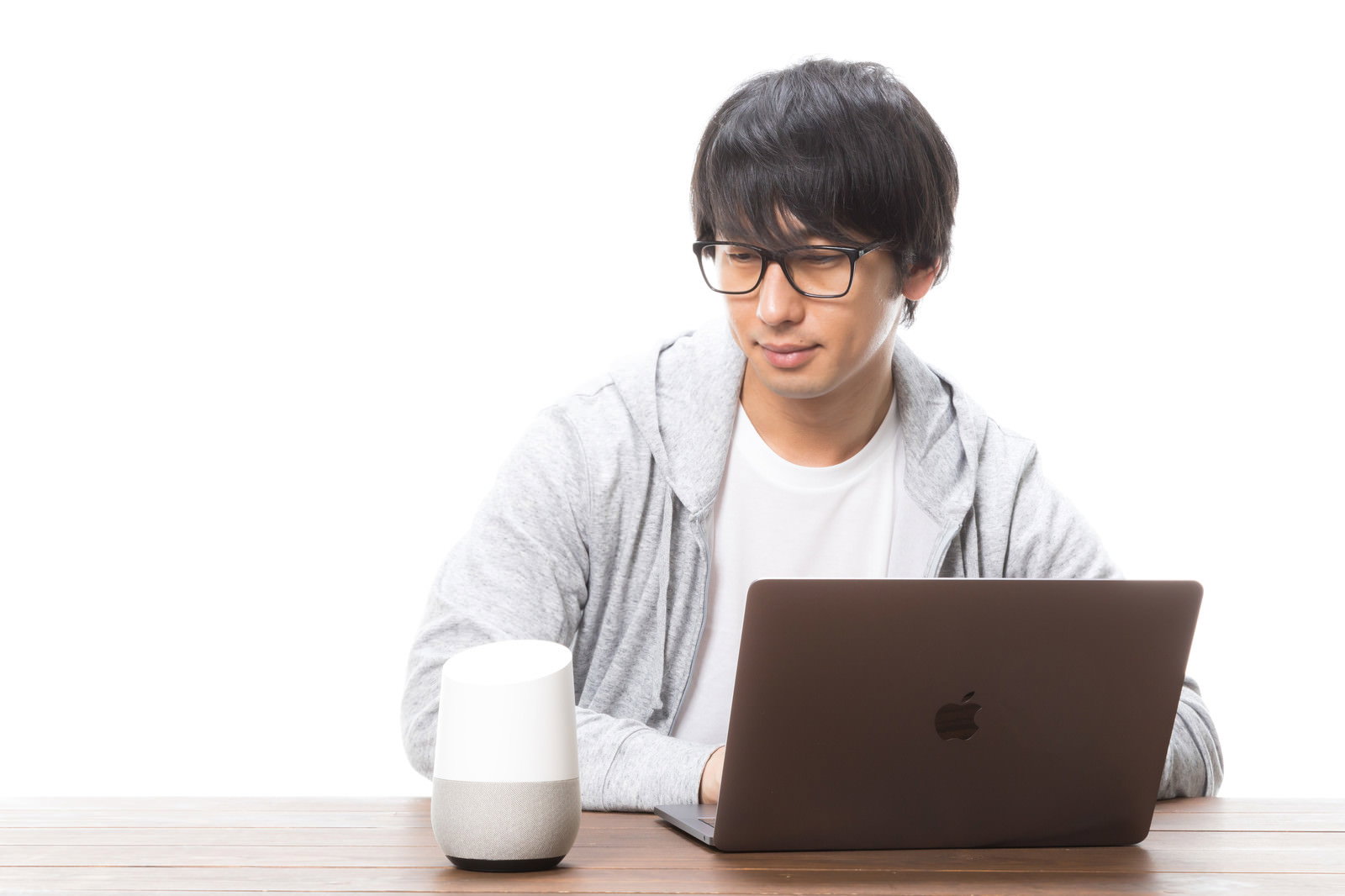 ペン型デバイスを口に当てて考えるスーツの男性［モデル：大川竜弥］