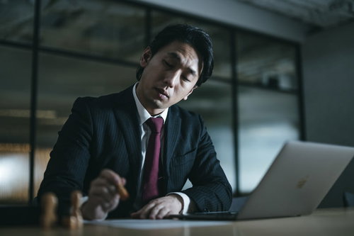 判子を押しに夜遅くまで残業する会社役員男性