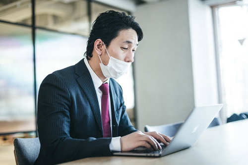 息苦しくて鼻出しマスクで作業する会社員男性