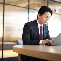 会議室で黙々と資料を作るプログラマー社員の写真