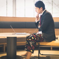 リモート会議で上半身スーツ、下半身パジャマの男性の写真