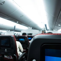 フライトを待つ旅客たちが機内の座席に座る光景の写真