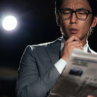 ビジネスのトレンドをチェックする新聞を読む男性の写真