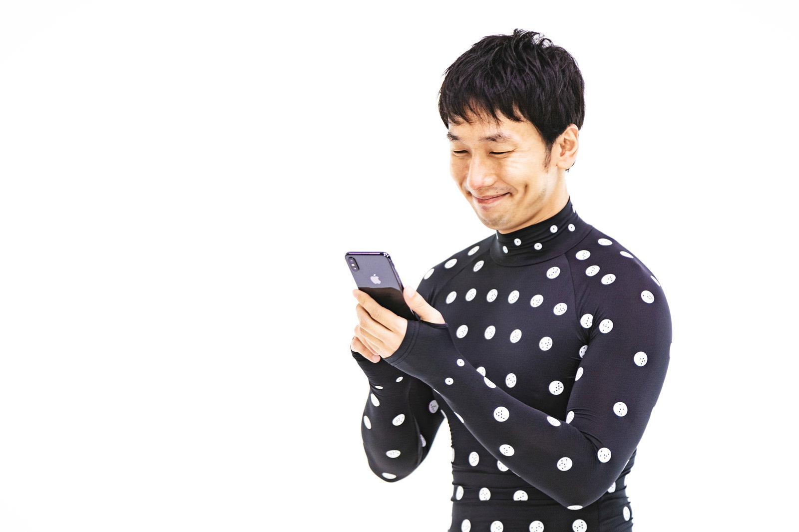 ZOZOSUITを着用してスマートフォンを見る笑顔の男性［モデル：大川竜弥］