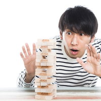 崩れる瞬間、ザ・ワールドを発動するジェンガの男性の写真