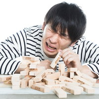 ジェンガ崩壊に泣く男性の写真