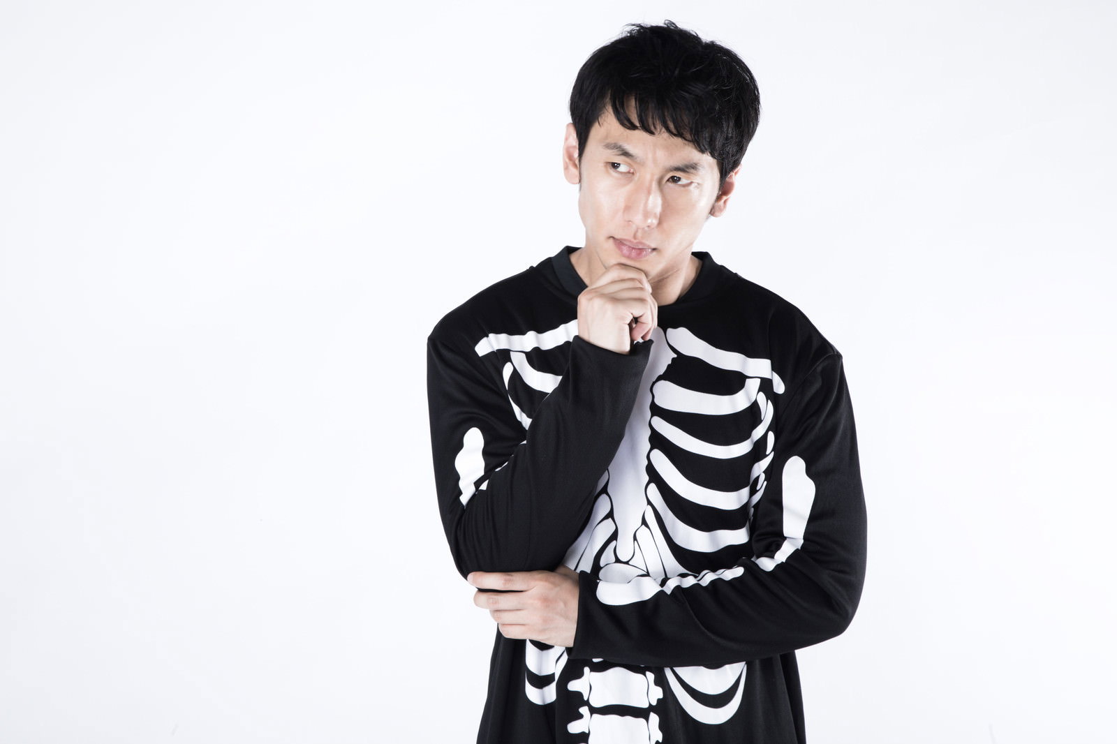 骸骨のコスプレをして考えるポーズを取る男性