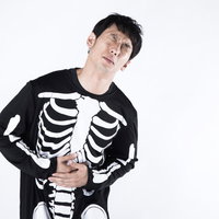 内臓がないのに腹痛ポーズをとるハロウィンコスプレ男性の写真