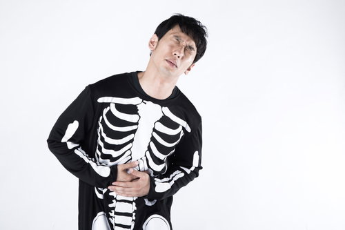 内臓がないのに腹痛ポーズをとるハロウィンコスプレ男性