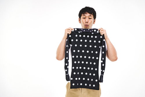 着用前にZOZOSUITのタグの向きを確認する男性