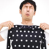 採寸ボディースーツを体に当てる男性の採寸風景の写真