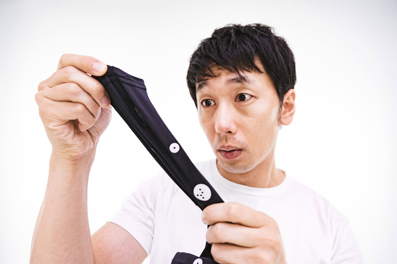 採寸ボディースーツの伸縮性に驚いた表情の男性［モデル：大川竜弥］
