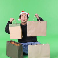 クリスマスセールで買い物しまくるサンタ帽姿の男性の写真
