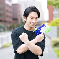 水鉄砲を構えてポーズをキメるおっさんゲーマーの写真