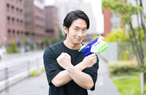 水鉄砲を構えてポーズをキメるおっさんゲーマー