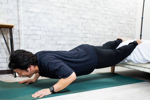 自宅で筋トレ、腕立て伏せをする運動不足マン