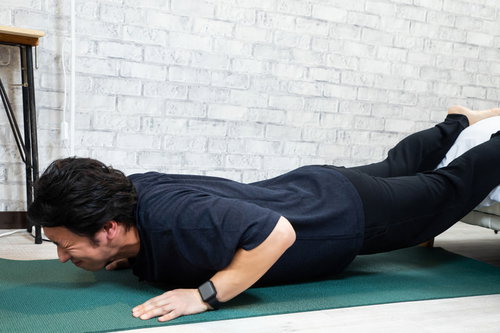 自宅で筋トレする男性が腕立て伏せに取り組む