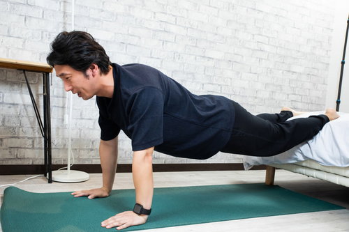 運動不足を解消するため自宅で腕立て伏せをはじめる男性