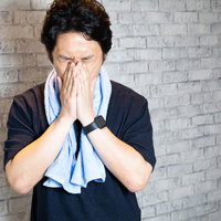 ジムでのトレーニング後に疲れた表情をする男性の写真