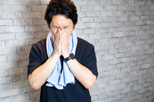 ジムでのトレーニング後に疲れた表情をする男性
