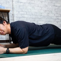 険しい表情でプランクを続ける男性の体幹トレーニングの写真