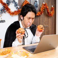 ハロウィン仮装でオンライン記念撮影、パソコンの前でポーズを決める男性の写真