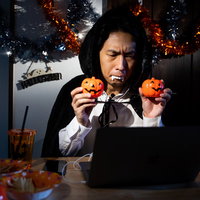 ハロウィンの内装デコレーション済みでドラキュラ仮装のスタンバイ男性の写真