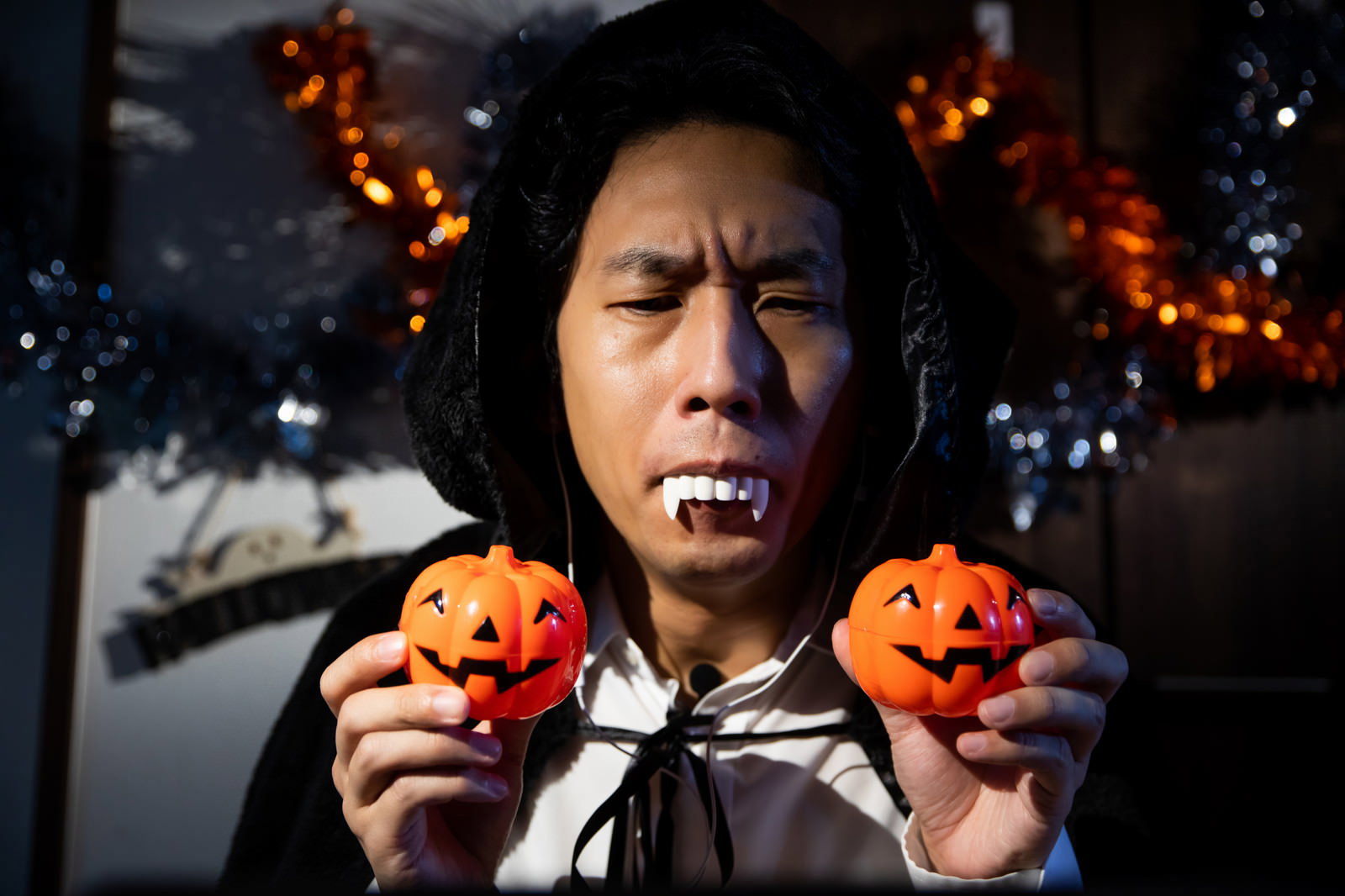 ハロウィンでドラキュラの仮装をした男性が牙を見せて威嚇している［モデル：大川竜弥］