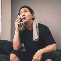 寝苦しいと思ったらエアコンの故障が発覚した暑い部屋で体調不良の男性の写真