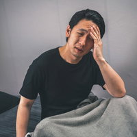 深酒で昨晩の記憶がない男性の二日酔い症状の写真