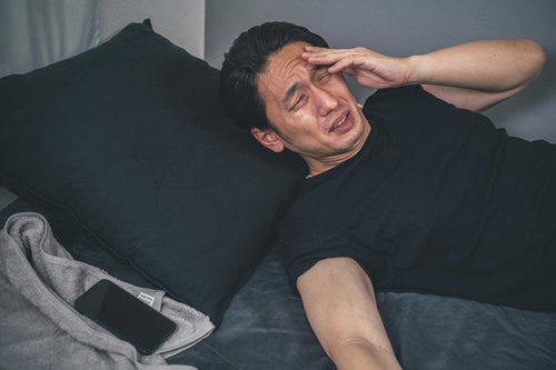 頭痛がひどくて目眩がする男性