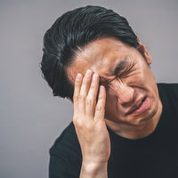 思い出そうとしても思い出せない時の頭痛に悩む男性の写真