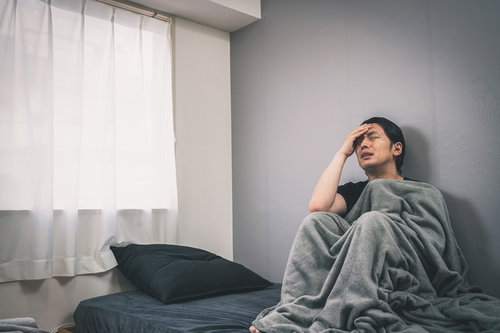 会社に行きたくない月曜日、ベッドで寝込む男性