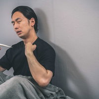 発熱つらいんごな男性（体温計チェック）の写真